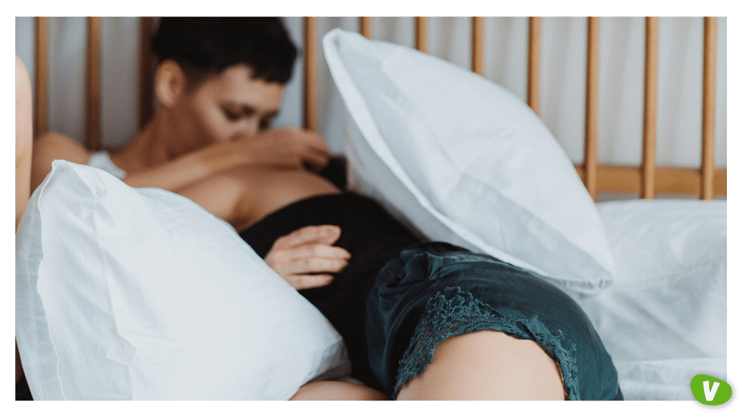 Two Women Lying in Bed Kissing