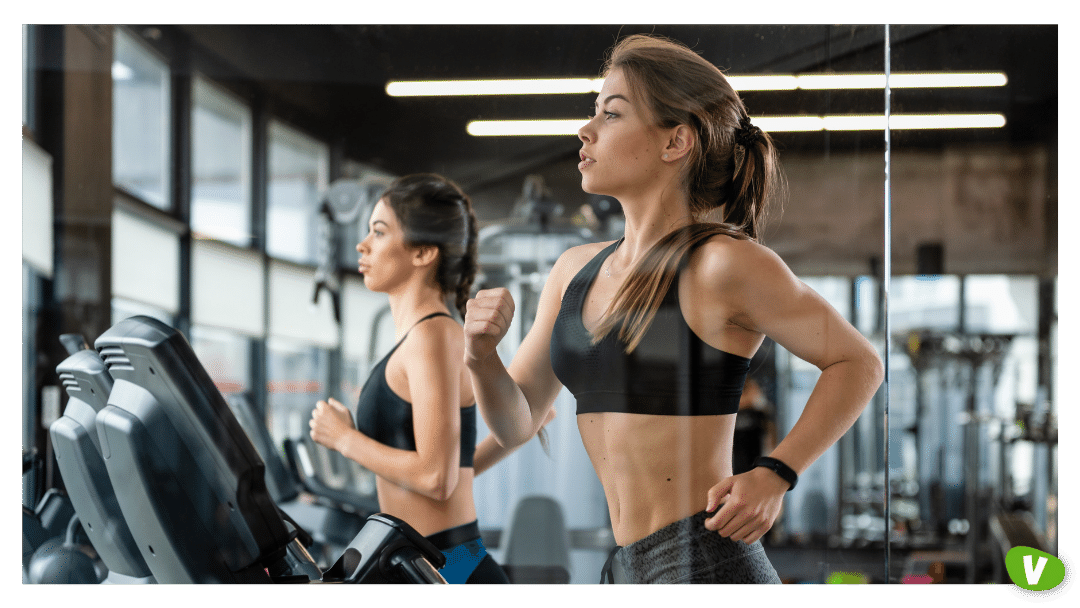 two women in the gym running on the treadmill