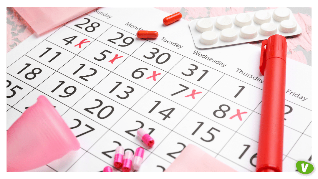 Menstrual Calendar with Feminine Products and Pills on Color Background