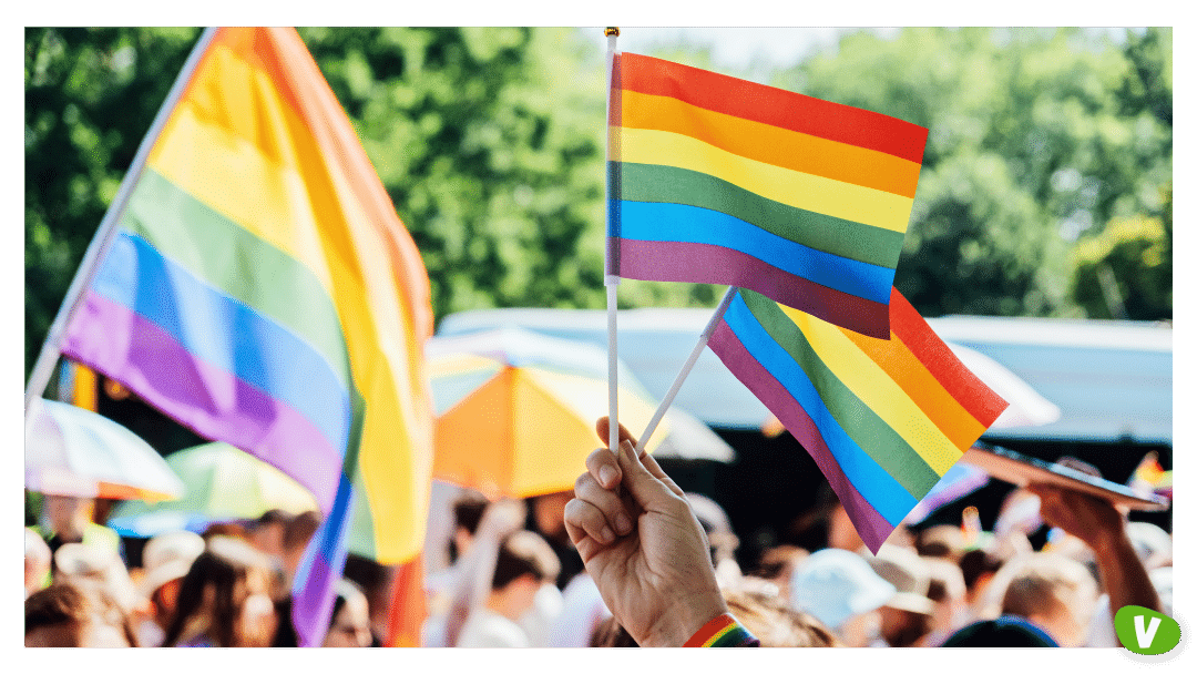 Hand in Rainbow Bracelet Waving Pride Flags in Parade⁠