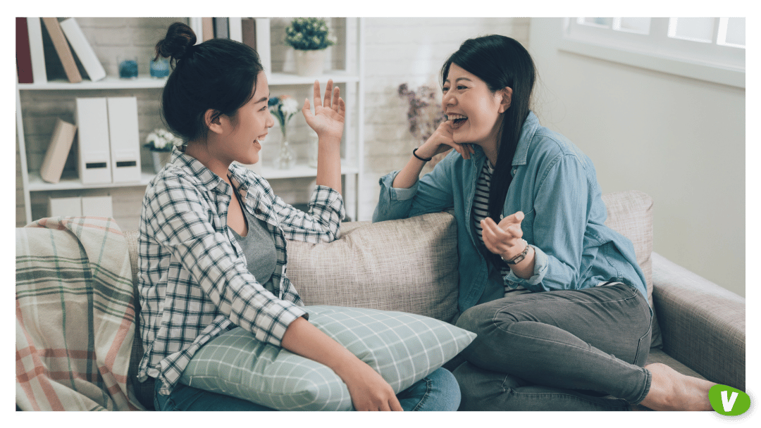 Two Laughing Asian Female Friends Talking