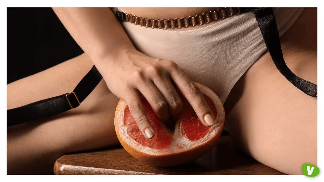 Young Woman with Half of Grapefruit Sitting on Dark Background, Closeup. Concept