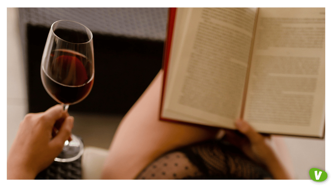 Woman in Sexy Lingerie Reading Book with a Wine Glass